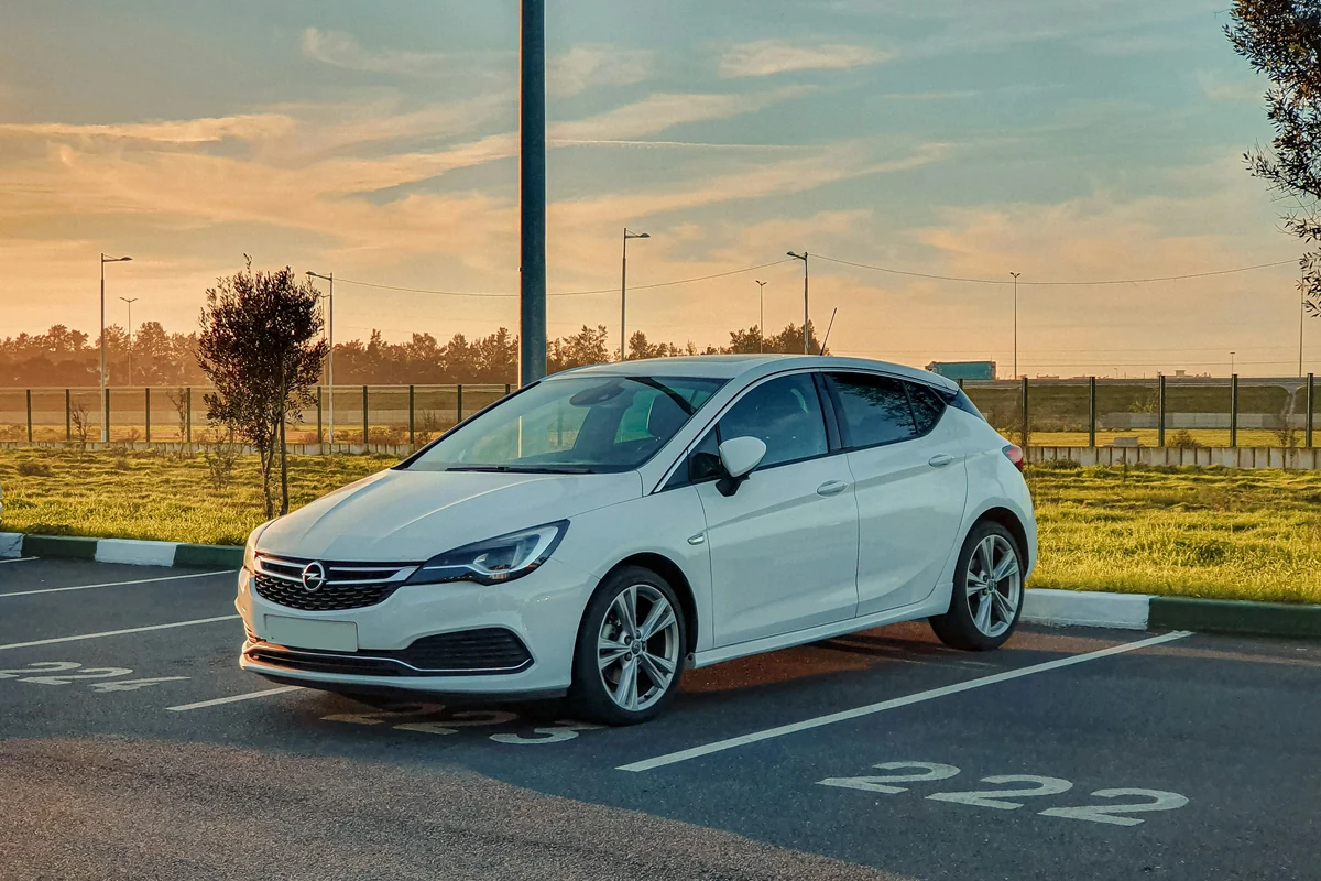 Gepflegter weißer Opel Astra in Dreiviertelansicht bei natürlichem Abendlicht
