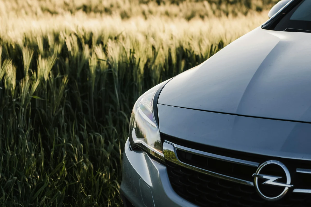 Detailansicht der Front eines gepflegten silbernen Opel Astra an einem Getreidefeld