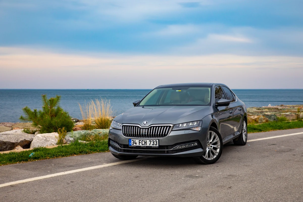 Moderner grauer Škoda Superb in Dreiviertelansicht bei Tageslicht
