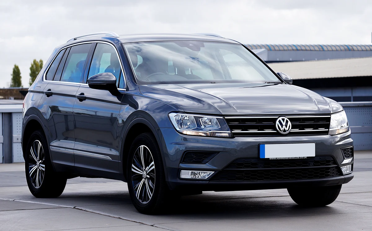 Gepflegter grauer Volkswagen Tiguan vor einer schlichten Gebäudefassade