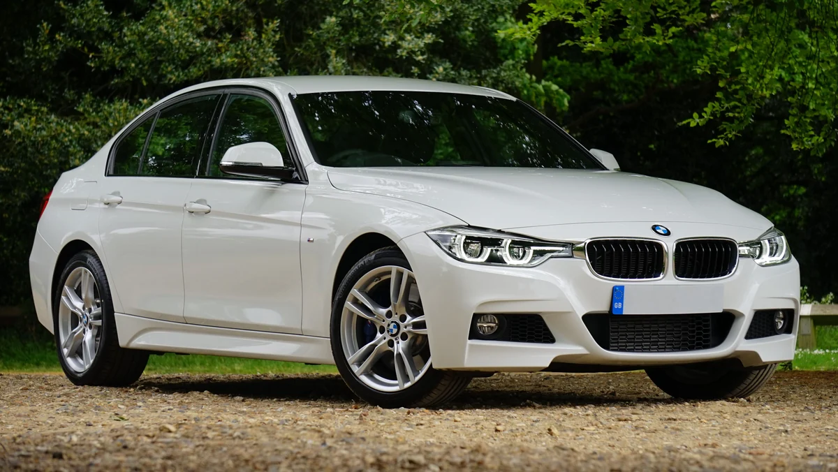 Weißer BMW 3er in Dreiviertelansicht auf einem ruhigen Platz im Grünen