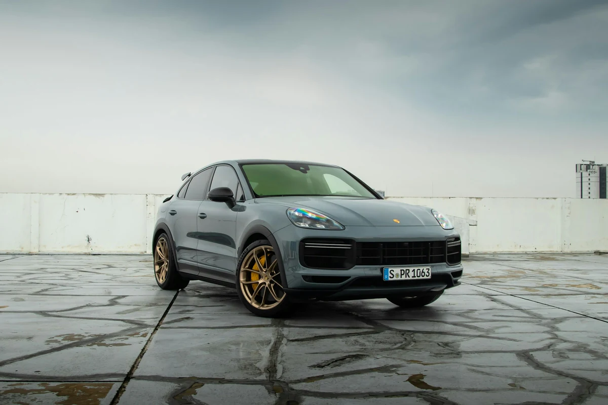 Grauer Porsche Cayenne auf einer offenen Parkfläche bei natürlichem Tageslicht