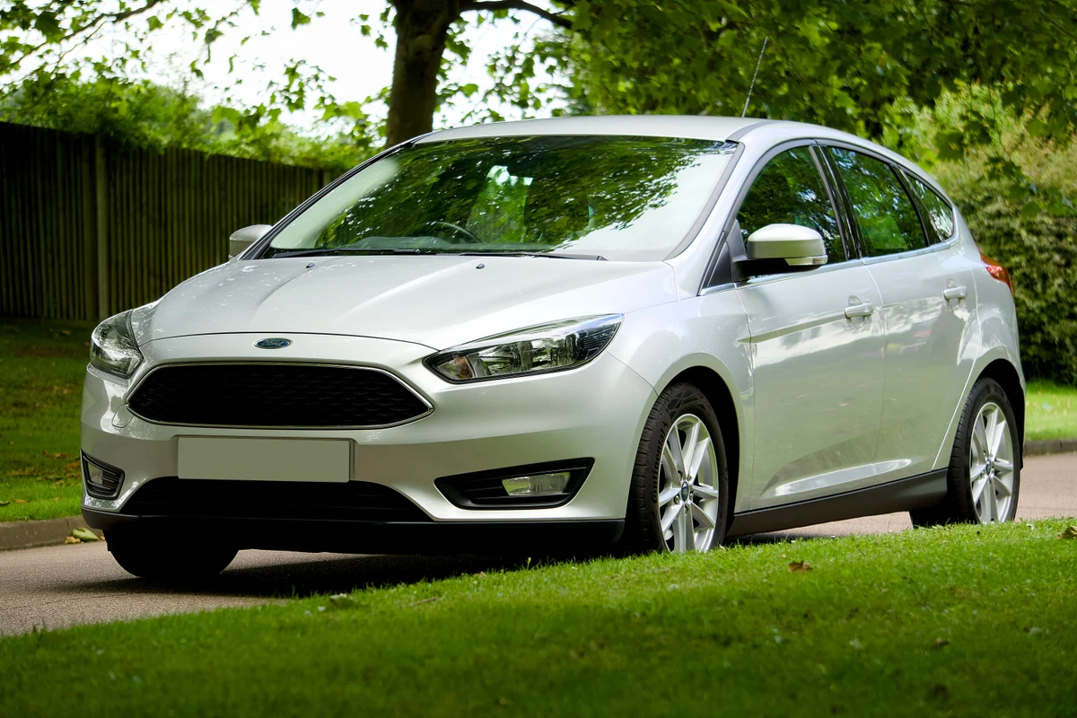Silberner Ford Focus in Dreiviertelansicht auf einer ruhigen Straße im Grünen