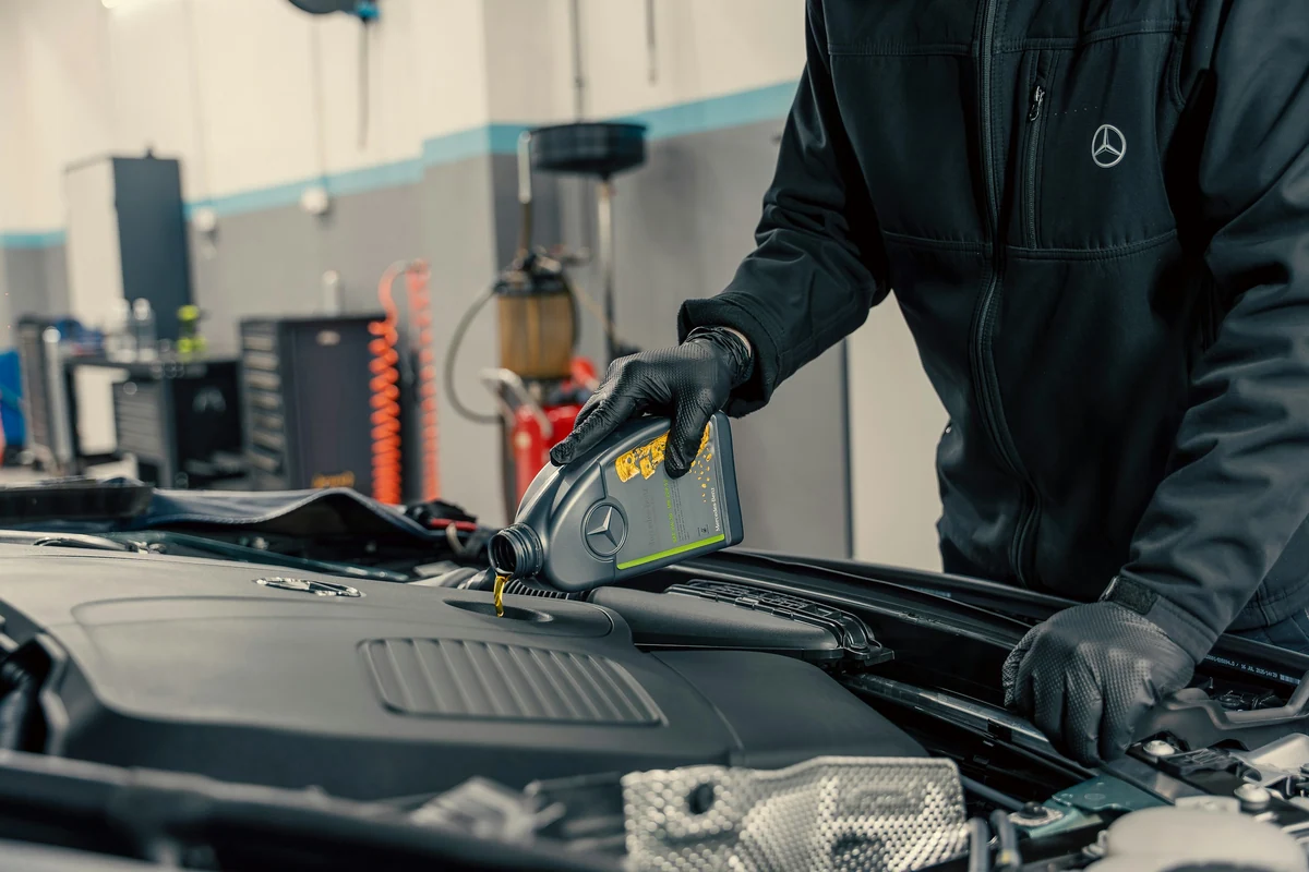 Arbeiten im geöffneten Motorraum eines modernen Pkw in einer Fahrzeugwerkstatt