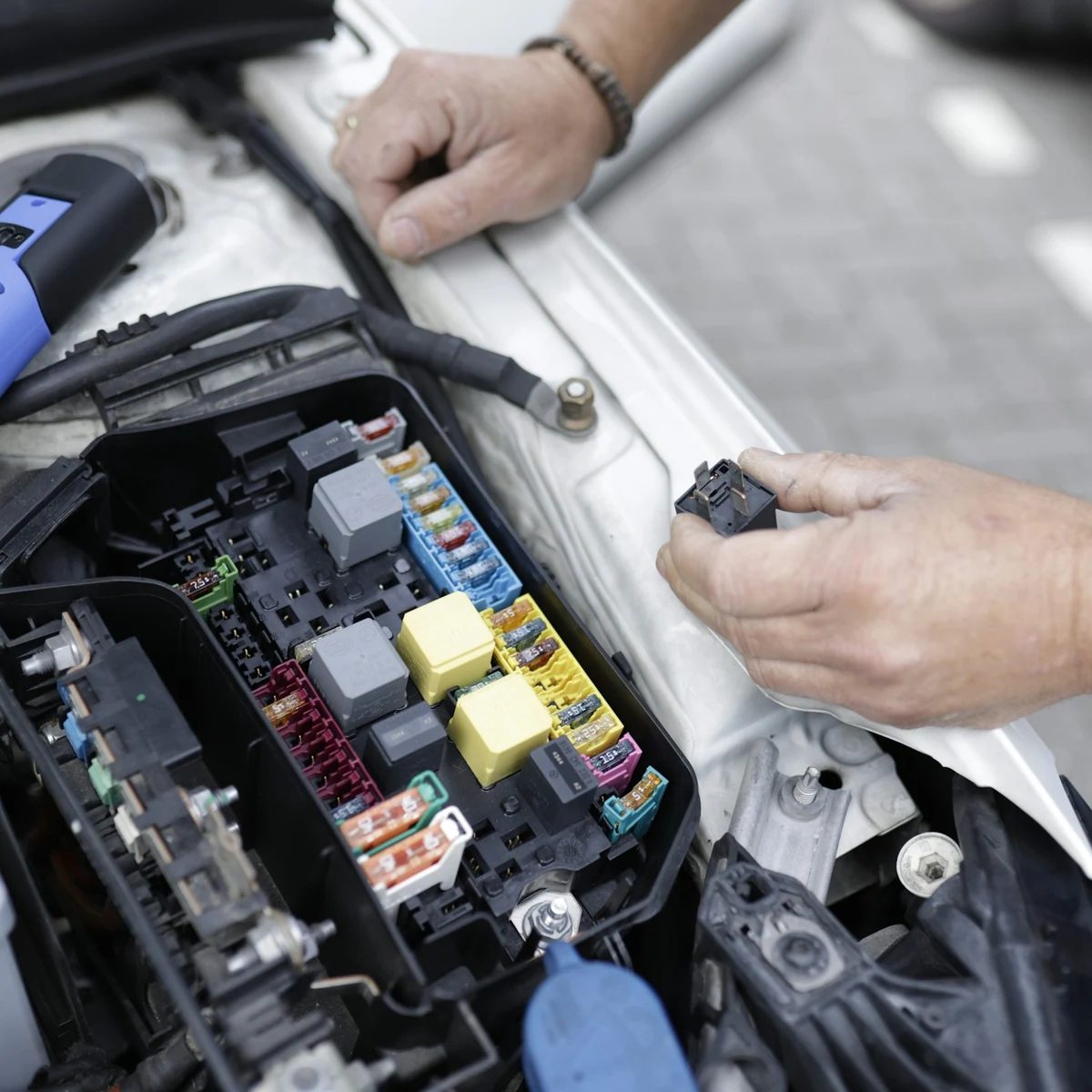 Prüfarbeiten an der Fahrzeugelektronik im geöffneten Motorraum