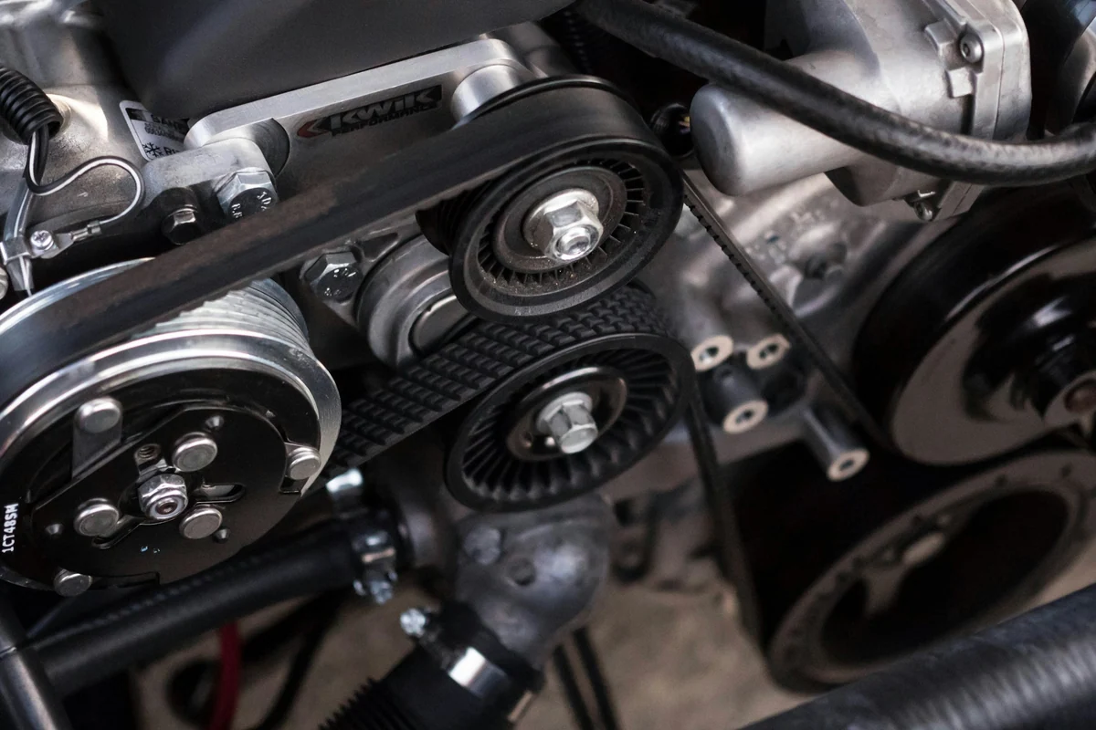 Realer Pkw-Motor mit sichtbarem Riementrieb als technische Detailaufnahme