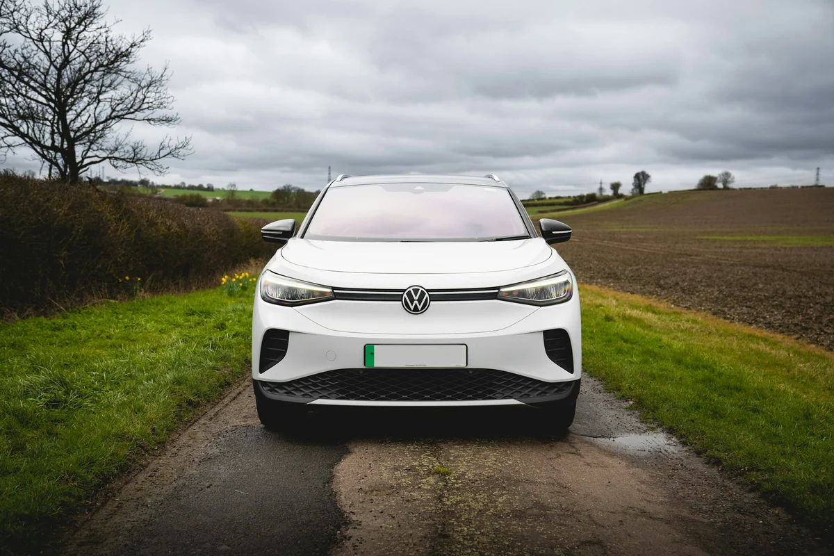 Weißer Volkswagen ID.4 auf einem ruhigen Weg im Grünen