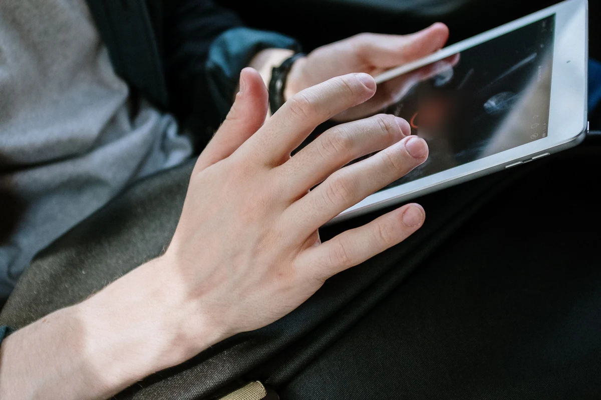 Hände bei der digitalen Eingabe auf einem Tablet im Fahrzeuginnenraum