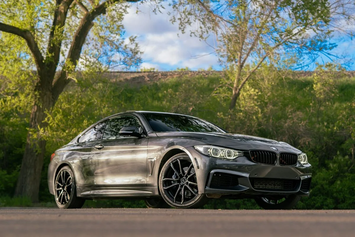Graues sportliches Coupé vor Bäumen im Tageslicht